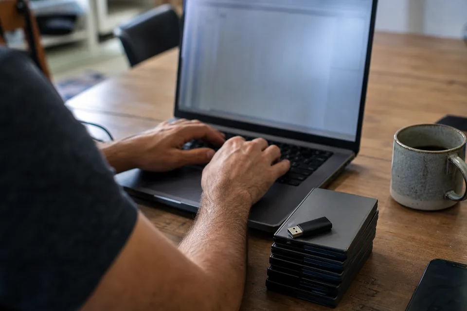 Hands on a laptop exporting comma separated data files