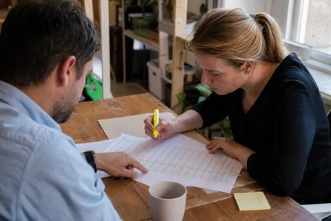 Colleagues reviewing a printed table report at a meeting table