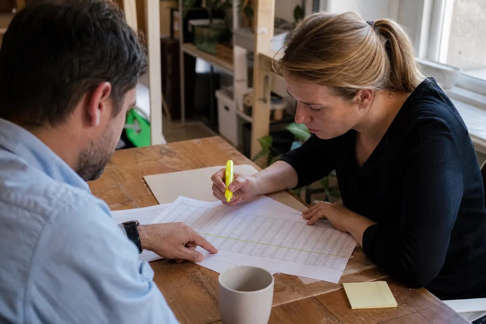 Colleagues reviewing a printed table report at a meeting table